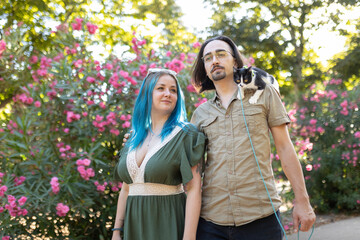 Young couple walking with cat on leash in park