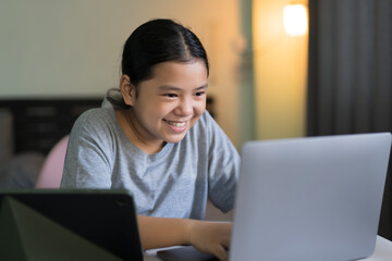 study online class by asian child smile learning on computer laptop or kid girl student fun studying or young people happy learn from home school by tablet video call technology education or notebook