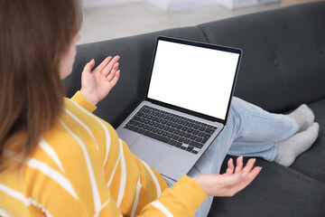 Woman having online consultation with doctor via laptop on sofa at home, closeup
