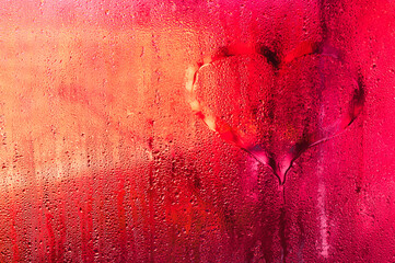 sheet of transparent window covered in moisture. red wet glass background. Foggy window with heavy condensation, water droplets forming liquid texture on smooth glass plate.