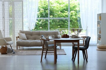 Beautiful table setting, chairs and decor in dining room. Interior design