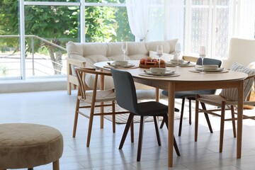 Beautiful table setting, chairs and decor in dining room. Interior design