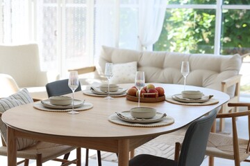 Beautiful table setting, chairs and decor in dining room. Interior design