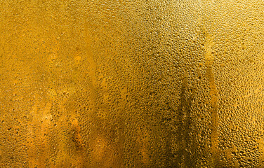 wet glass background. drops on the glass. yellow wet glass window for design and projects backdrop