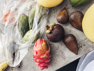 Assorted exotic fruits including mangosteen, dragon fruit, and snake fruit, showcasing vibrant...