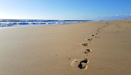 Footprints on sandy beach near ocean.