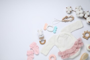 Cute baby clothes, accessories and cotton flowers on white background, flat lay. Space for text