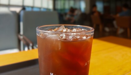 Glass of Iced Coffee on Cafe Table in Bright Sunlight