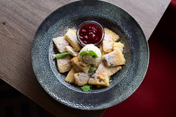 Traditional Austrian Kaiserschmarrn served with sour cherry sauce and a scoop of vanilla ice cream.