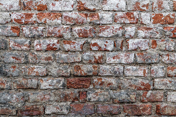 abstract background of an old painted white dirty and shabby red brick wall close up