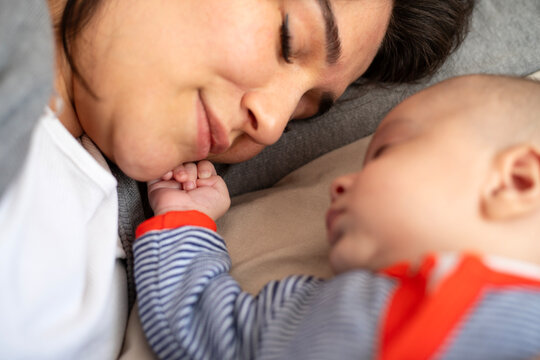 Young mother and baby napping at home