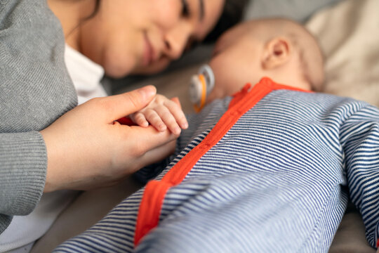 Young mother and baby napping at home