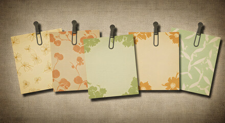 Floral Patterned Cards Clipped to a Textured Surface Displaying Vintage Charm