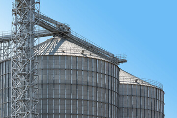 Agricultural Silos - Building Exterior, Storage and drying of grains, wheat, corn, soy, sunflower against the blue sky.