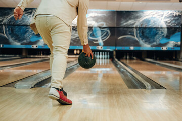 About to throw the ball. Close up view of man that is playing bowling
