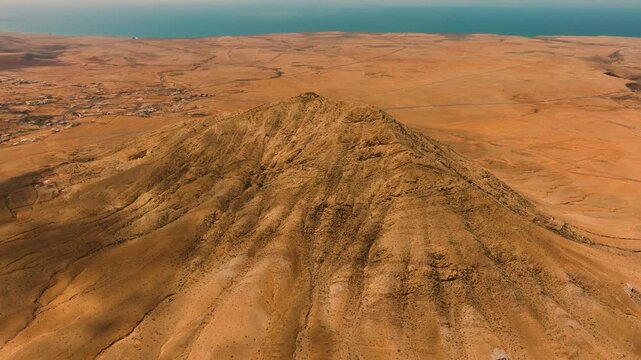 Aerial view of Mount Tindaya under midday sun with clouds casting shadows, Fuerteventura, Canary Islands