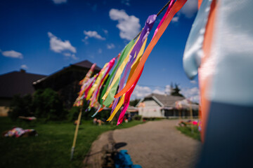 Colorful ribbons fluttering in the wind at an outdoor event on a sunny day, with a clear blue sky...