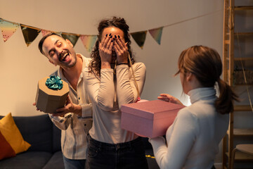 Friends giving surprise gifts at birthday party
