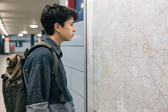 Teenager girl checking subway map in station during morning commute