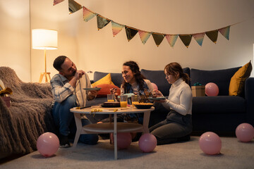 Friends eating homemade food at birthday party celebration