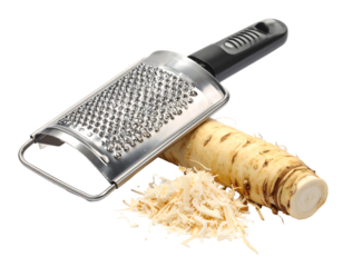 Grating fresh horseradish root with a metal grater, isolated on transparent background, showing grated horseradish pieces, light grey metal grater, and a whole horseradish root
