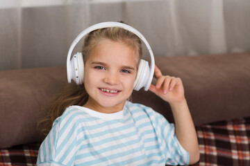 child girl wearing headphones listens to music And dancing at home. favorite music. Generation Z. 