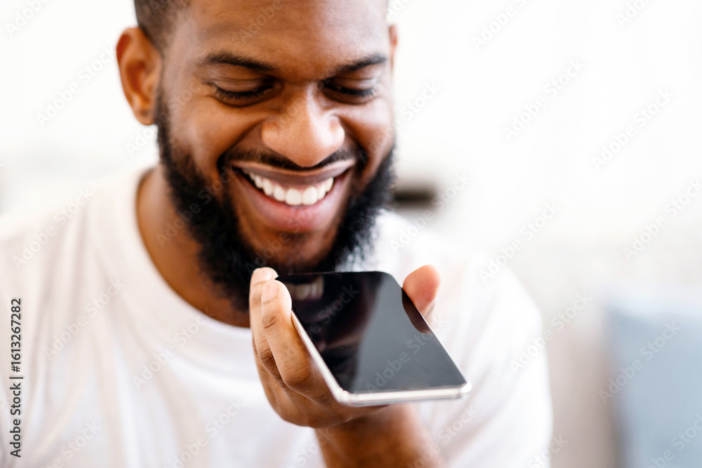 Poster closeup of african guy with phone using voice assistant app talking holding smartphone near mouth in