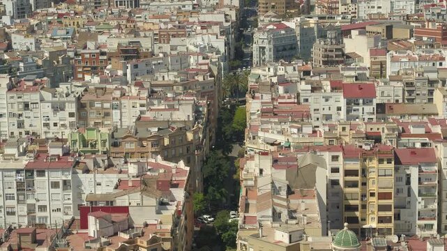 Orbiting aerial drone shot over Valencia with upward camera tilt revealing dense urban architecture and city buildings