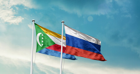 Comoros and Russia friendship flags are waving in the sky. Double country Flag waving with mast. Comoros Russia national flag for agreement.