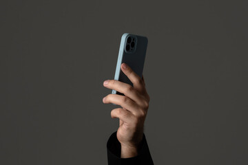 Hand Holding Smartphone Against Minimal Background