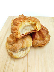 Golden Cream Puffs on Wooden Board