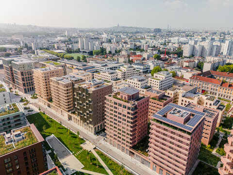 Aerial view of the The Paris 2024 Olympic and Paralympic Village with solar panels and green roofs casting shadows over lush green spaces, Village des Athl&Atilde;&uml;tes Olympiques, &Atilde;Žle-de-France, France.
