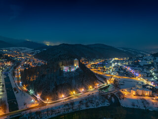 Lot nad zamkiem w Muszynie wieczorem zimą.