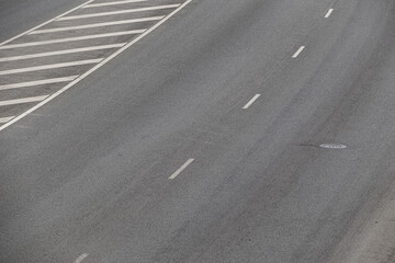 View of an asphalt road with road marking lines. Gray background with asphalt texture
