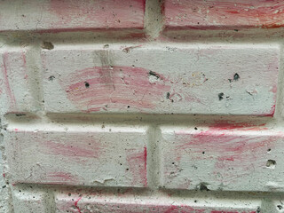 Textured Brick Wall with Weathered White Paint and Pink Stains Ideal for Home Decor and Renovation Projects