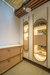 Modern interior with a fluted wood cabinet, backlit display niches, and a woven rattan ceiling....