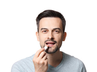 Handsome man applying lip balm onto his lips on white background