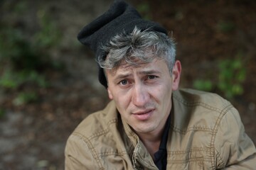 Portrait of poor homeless man outdoors, space for text