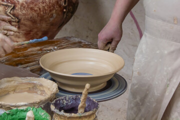 child's hands painting clay plate close-up, pottery, clay modeling, potter and child painting clay...