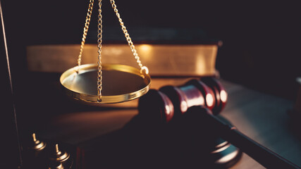 Justice scale and judge’s gavel on wooden table, symbolizing judgment, law, fairness, and legal...
