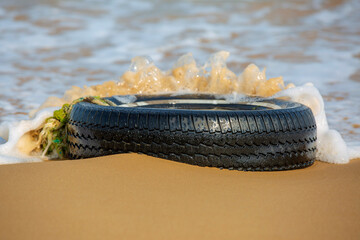 waste car tire image on the beach environmental problems