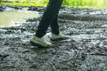Man with a shoes stands on the dirty ground.