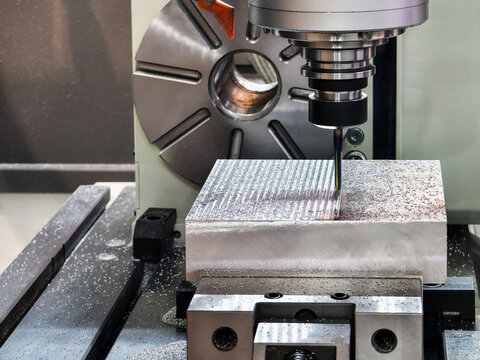 Precision milling process on metal block in modern workshop during daylight hours in a clean industrial environment