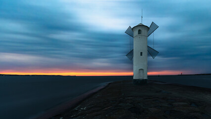 Stawa Młyny lighthouse in Świnoujście, Poland, on the shore of the Baltic Sea. A lighthouse in the shape of a mill at sunset.