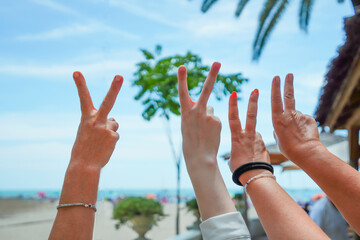 Female hands together showing a gesture of luck, friendship,cool against the sea