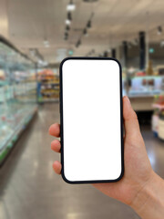 Cell phone with transparent screen. In the background, out of focus, the shelves of a supermarket. Digital shopping list.