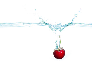 Fresh Red Cherry Splashing Into Clear Water With Bubbles Under Bright Light