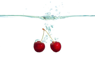 Fresh Sweet Cherries Splashed in Clear Water on White Background