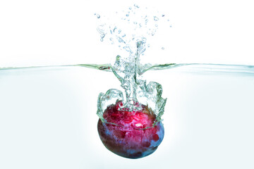 Fresh Plum Splashing in Water with Bubbles and Ripples