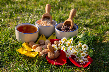 Natural Ingredients Arranged Outdoors on Grass with Honey, Grains, and Flowers